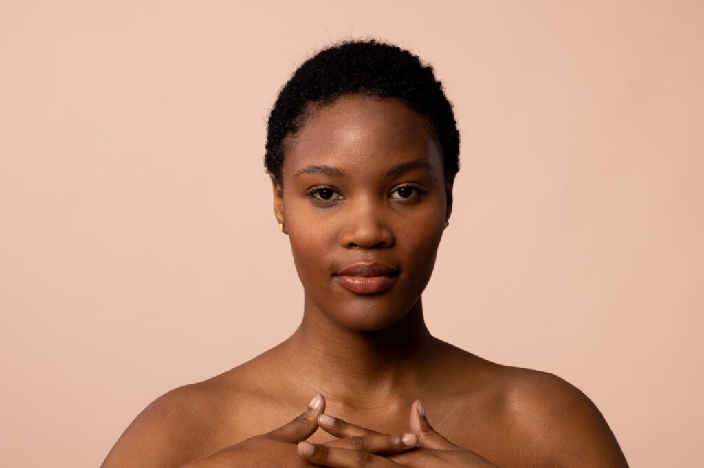 African american woman with short hair with hands clasped on chest