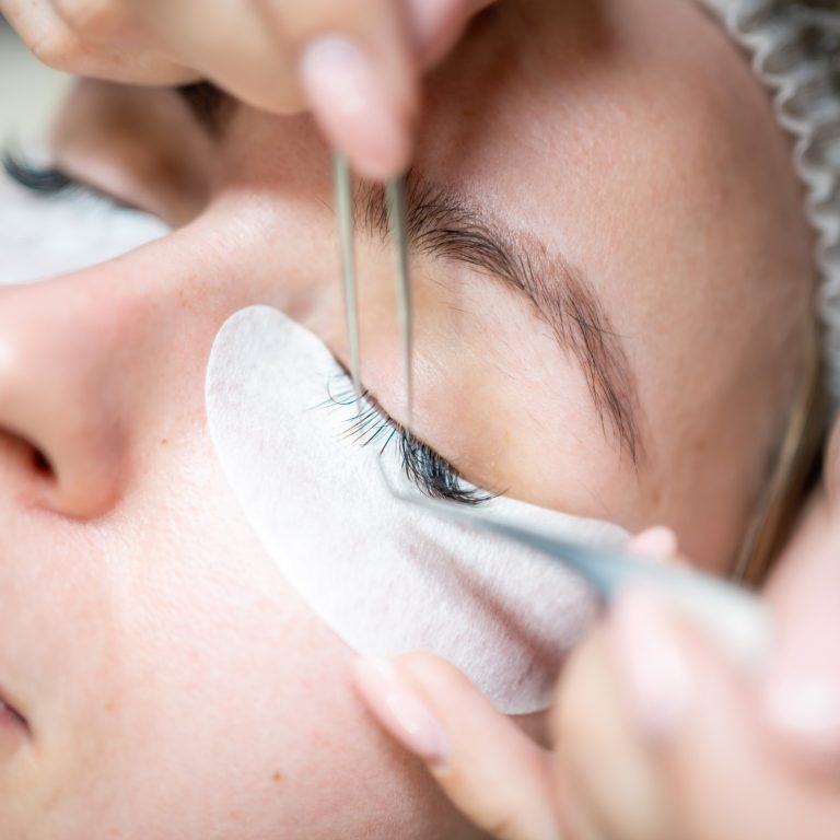 Eyelash extension procedure in beauty salon. Lashes close up. Concept spa lash.