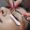 Eyelash extension process to cute young woman in beauty salon